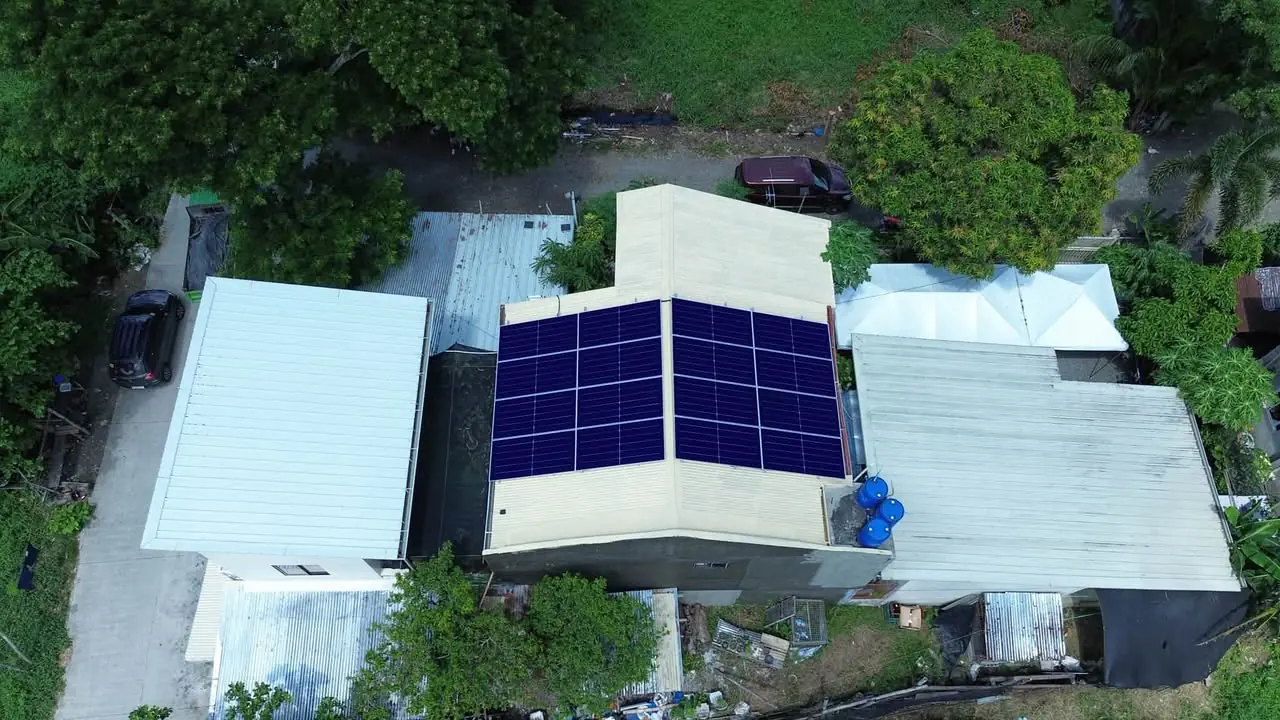 Aerial view of solar panels spanning both slopes of a light-colored roof