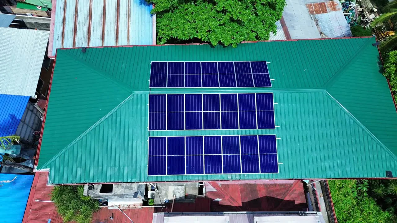 Aerial view of 21 solar panels arranged across a green metal roof